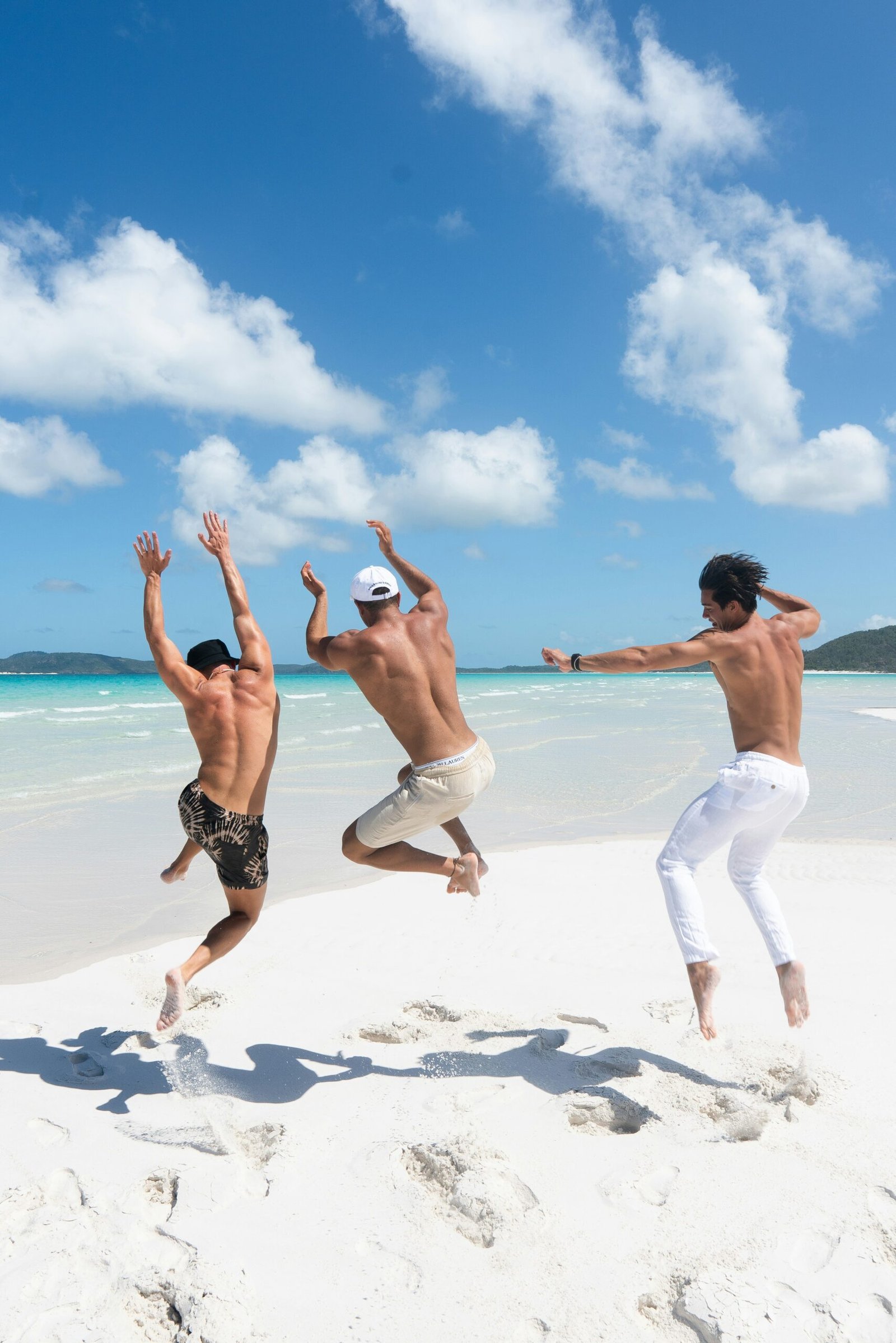 Two women running happily on a white sand beach